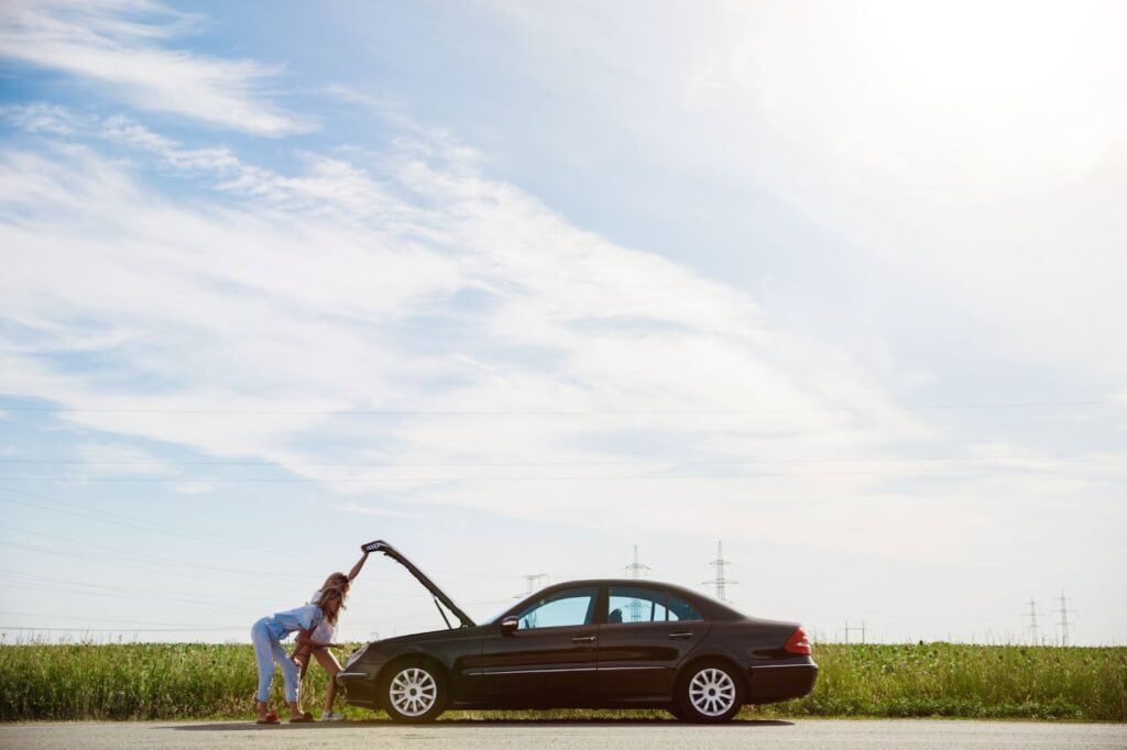 Due donne controllano il motore dell'auto